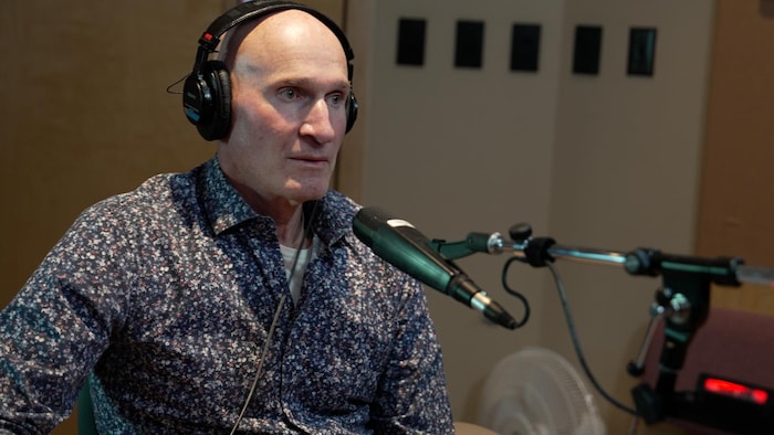 Stephen Mooney derrière un micro dans un studio de radio, le 13 mars 2025.