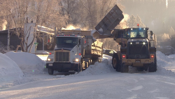 De l'équipement lourd procède au déneigement d'une rue. 