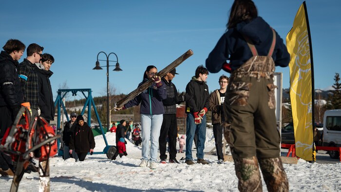 Une jeune s'apprête à lancer un billot de bois, le 21 février 2025. 