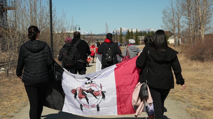 Des marcheurs avec une banderole se dirigent vers un paysage montagneux, le 26 avril 2024.