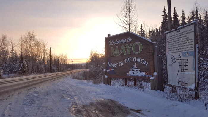 Enseigne à l'entrée du village de Mayo, au Yukon, en hiver, sur laquelle on peut lire, en anglais, Welcome to Mayo, Heart of the Yukon.