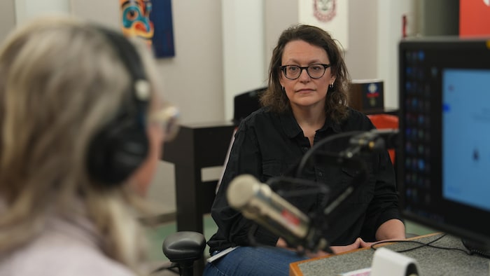 Tammy April behind the microphone in the studio.