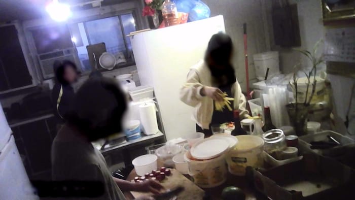 Une femme, une adolescente et un homme préparent de sushis dans une cuisine improvisée.