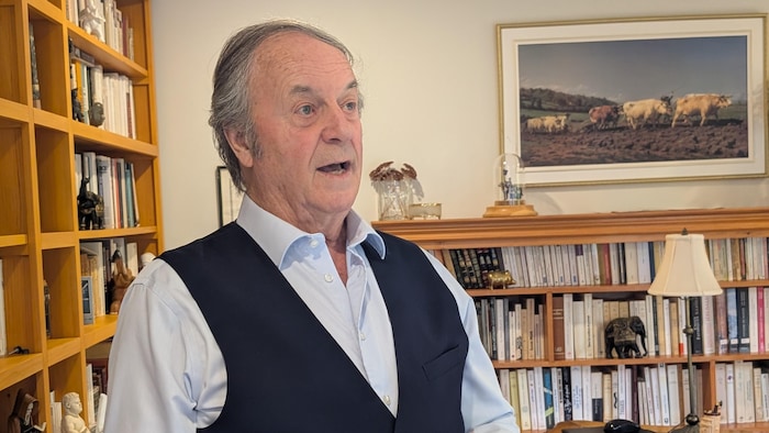 Un homme âgé dans une bibliothèque.