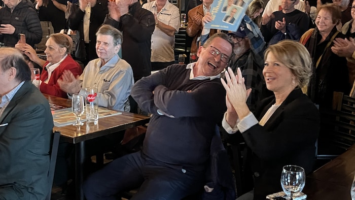 Le chef rit, au milieu d'une foule.