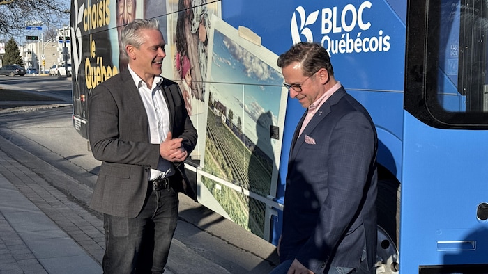 Deux hommes devant un autobus.