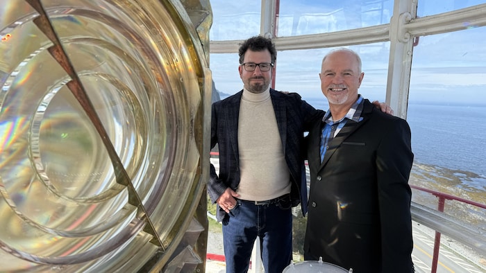 Marc-Antoine DeRoy et Yves Sohier posent à côté de la lentille du Phare de La Martre.