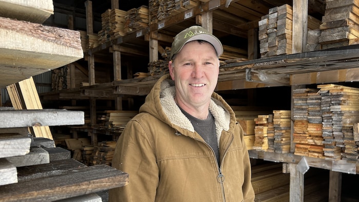 Yvon Doiron pose pour la photo dans les installations de sa scierie.