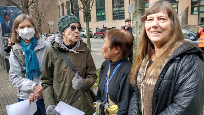 Quatre femmes à une manifestation pour les droits des migrants.