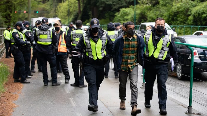 Zain Haq est arrêté alors qu'il bloquait le trottoir le long du Lions Gate Bridge Road lors d'une manifestation Extinction Rebellion à Vancouver, en Colombie-Britannique, le  3 mai 2021.