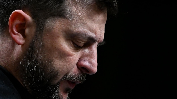 Il a la tête penchée vers l'avant et les yeux fermés.