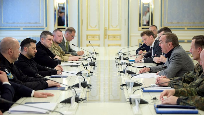 Les deux hommes se rencontrent, entourés d'autres dignitaires.