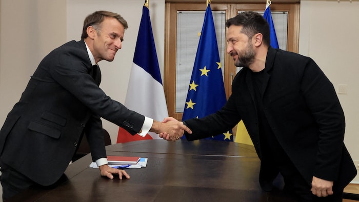 Le président ukrainien Volodymyr Zelensky (à droite) serre la main du président français Emmanuel Macron (à gauche).