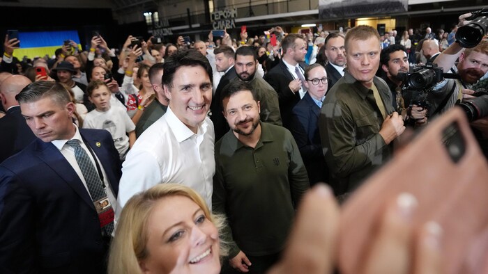 Justin Trudeau et Volodymyr Zelensky prennent un égoportrait avec une partisane. 