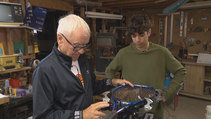 Zénon Chiasson installe le cordage d'une raquette.
