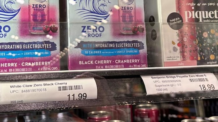 Une étagère de magasin sur laquelle se trouvent des boîtes en carton de canettes sans alcool de la marque White Claw.