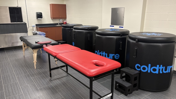 Une salle avec des tables de massage et des bains portables.