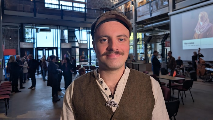 Un homme pose dans un musée.