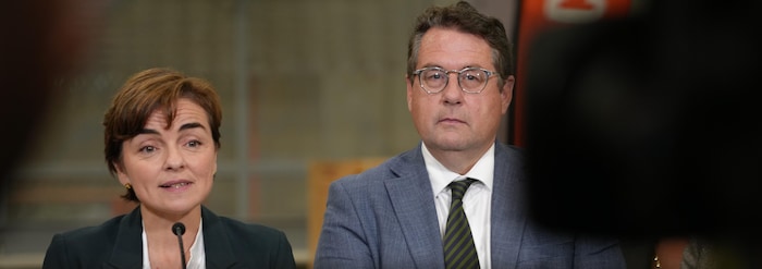 Christine Fréchette s'exprime au micro aux côtés de Bernard Drainville, aperçus derrière l'écran d'une caméra.