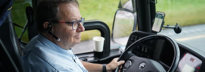 Un homme derrière le volant d'un autobus.