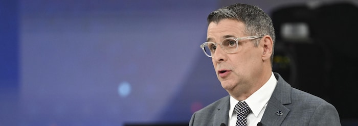Éric Duhaime s'exprime derrière son pupitre en faisant un geste des mains.