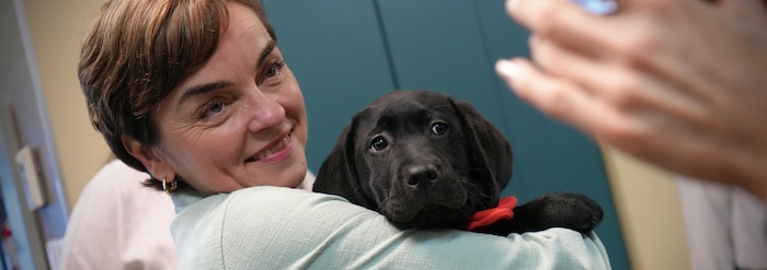 Christine Fréchette tient un chien Mira.