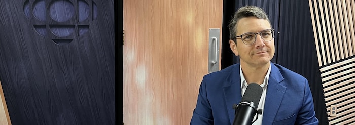 Un homme assis dans un studio de radio.
