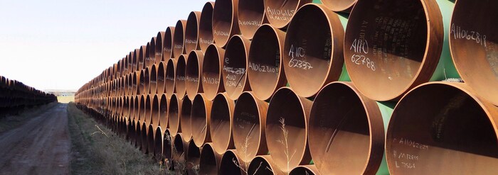 Des centaines tuyaux de pipeline empilés à l'extérieur.