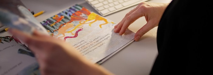 Une femme lit un livre pour enfants. 