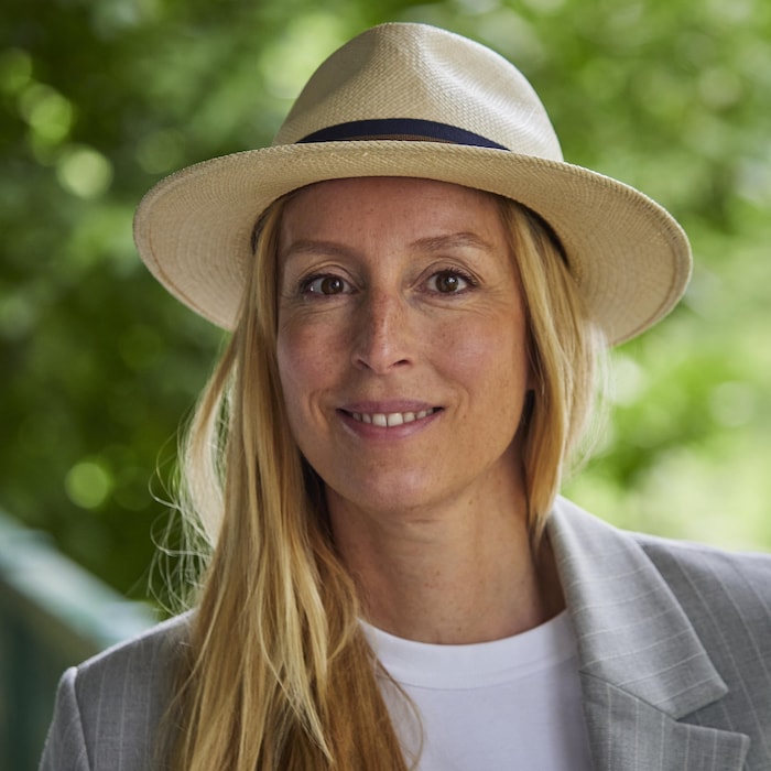 Une femme blonde porte un chapeau.