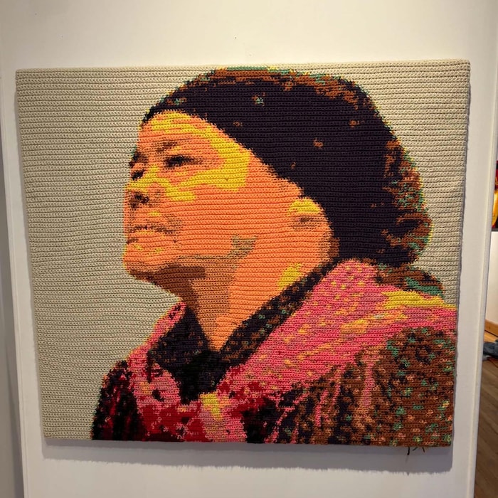 Une tapisserie représentant An Antane Kapesh.