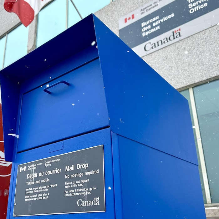 Une boîte de dépôt avec un drapeau du Canada en arrière.