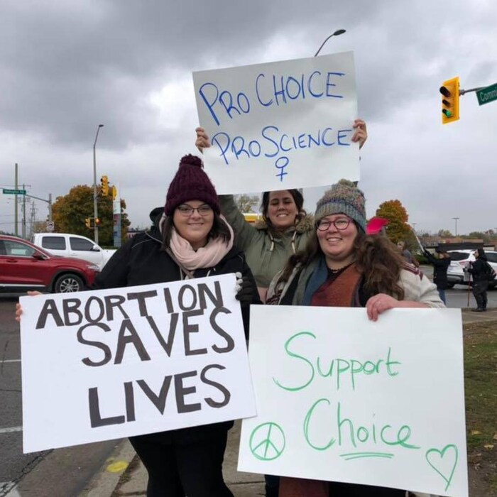 Malone, left and Surerus attend an anti-abortion counter-demonstration outside the London Health Sciences Centre in southwestern Ontario. They're shown with Surerus's sister Tiffany, middle.
