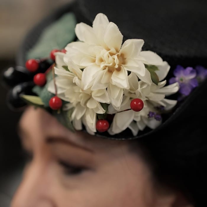 Gros plan sur une fleur blanche sur un chapeau.