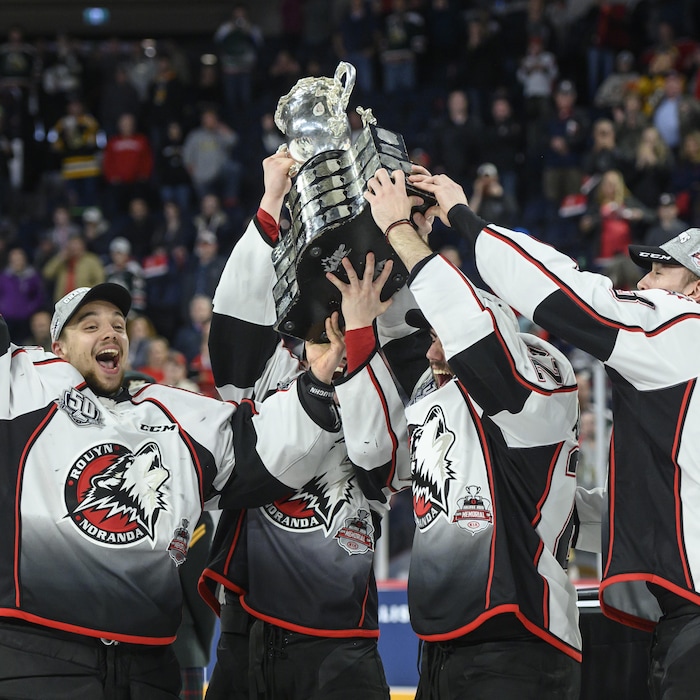 Des joueurs des Huskies soulèvent la Coupe Memorial sur la patinoire à Halifax le 26 mai 2019.
