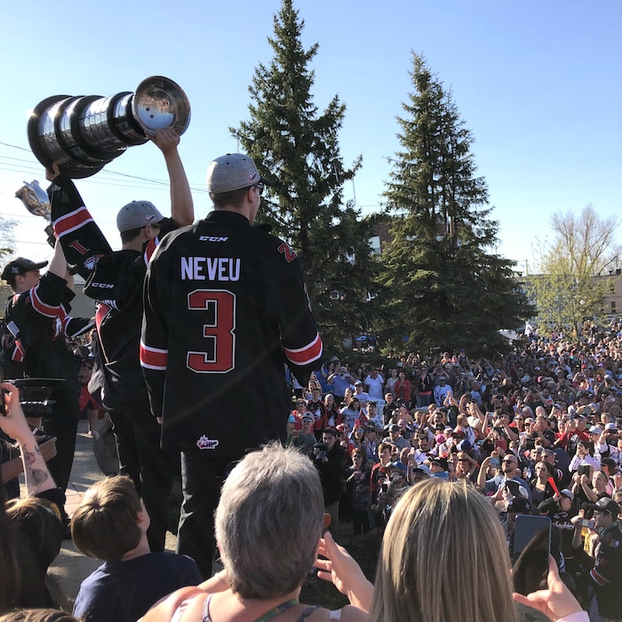 Des joueurs des Huskies soulèvent les coupes du Président et Memorial devant des centaines de personnes.