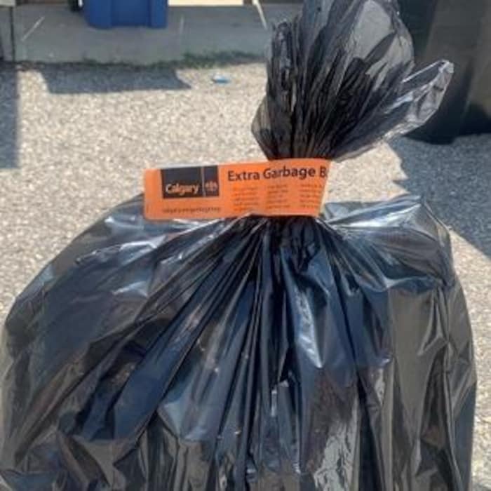 Un sac à ordures noir identifié avec une étiquette orange.
