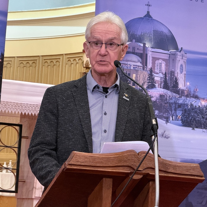 Ghislain Roy parle au micro derrière un lutrin.