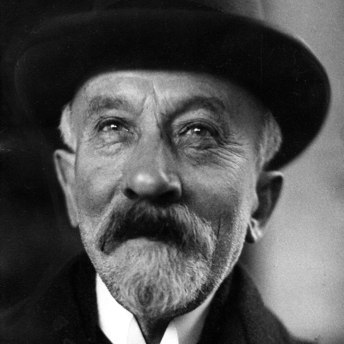 Photo en noir et blanc d'un homme âgé portant une barbe et un chapeau.