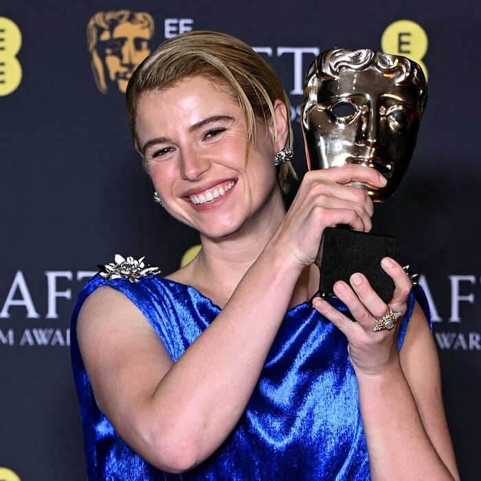 Une femme soulève un trophée.