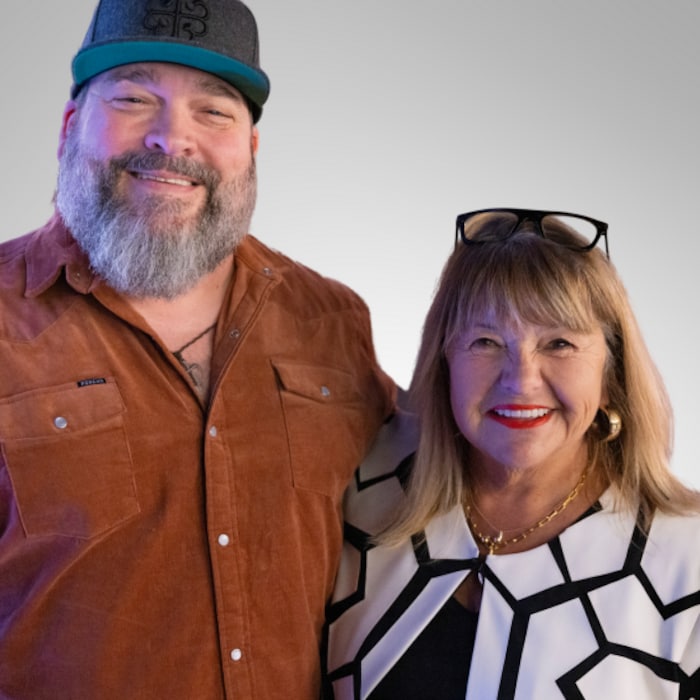 Un homme barbu et une femme blonde sourient.