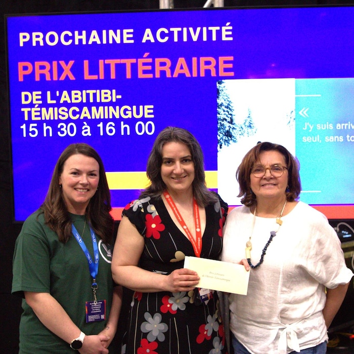 Trois femmes posent pour la caméra en souriant.