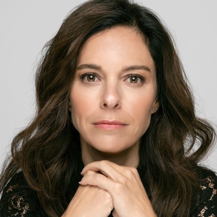 Une femme brune regarde l'objectif.
