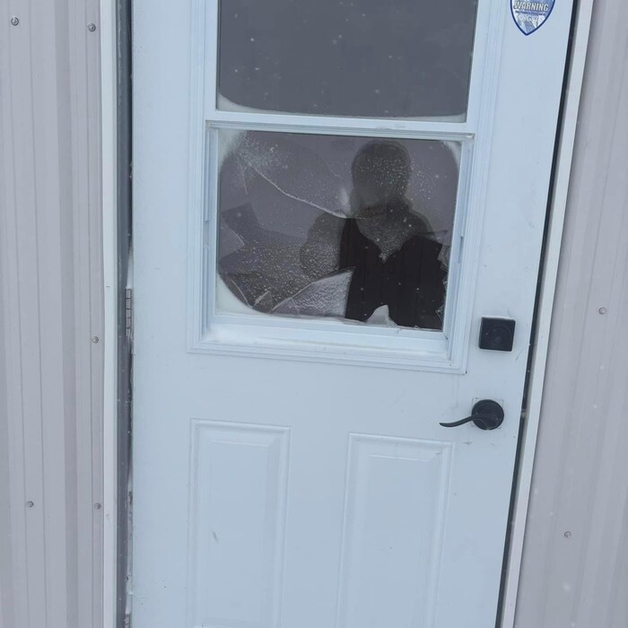 La vitre brisée d'une porte de cabane de pêche.