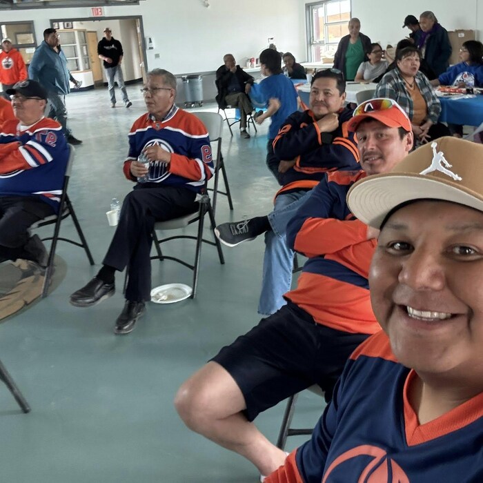 Shaun Moosenose regarde vers l'appareil photo avec d'autres partisans des Oilers.