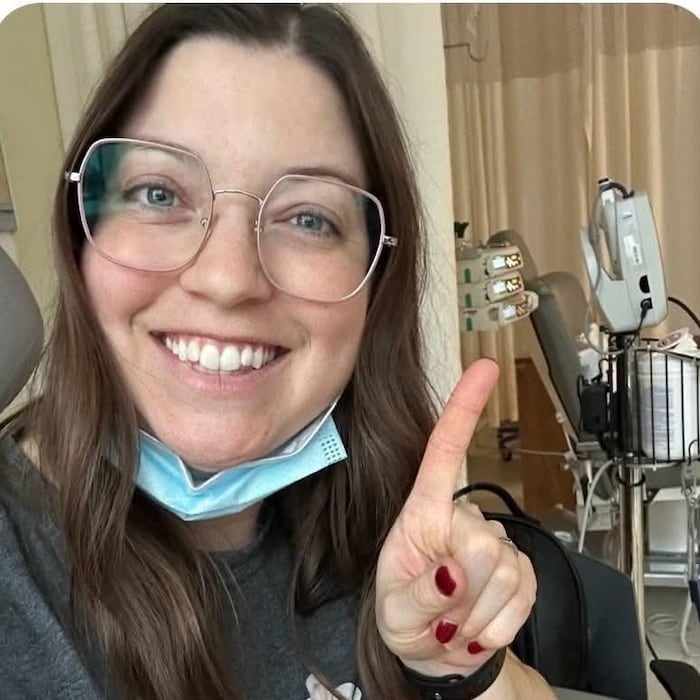 Dans une salle d'hôpital, Stéphanie Alain montre un doigt pour énumérer son traitement.