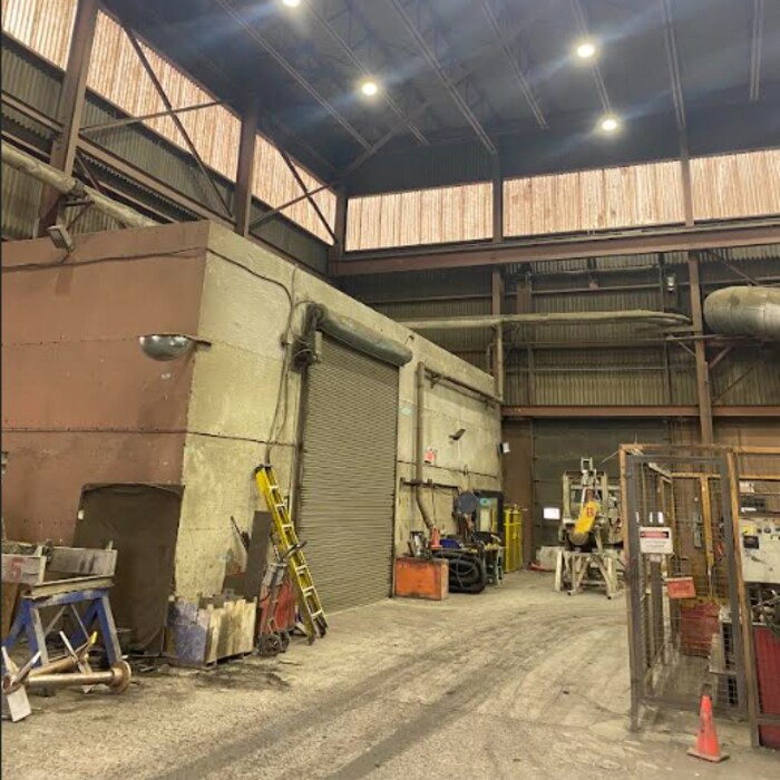 Intérieur de la raffinerie de l'usine, avec une porte de garage, une échelle et un haut plafond