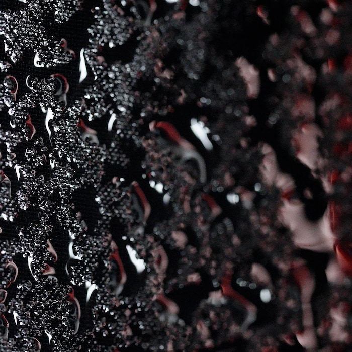 Gros plan montrant de l'eau qui perle sur du tissus synthétique.