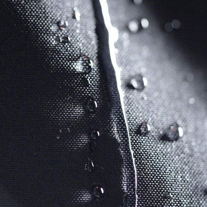 Gros plan montrant de l'eau qui perle sur du tissus synthétique.