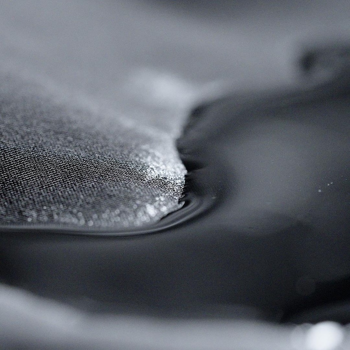 Gros plan montrant de l'eau qui perle sur du tissus synthétique.